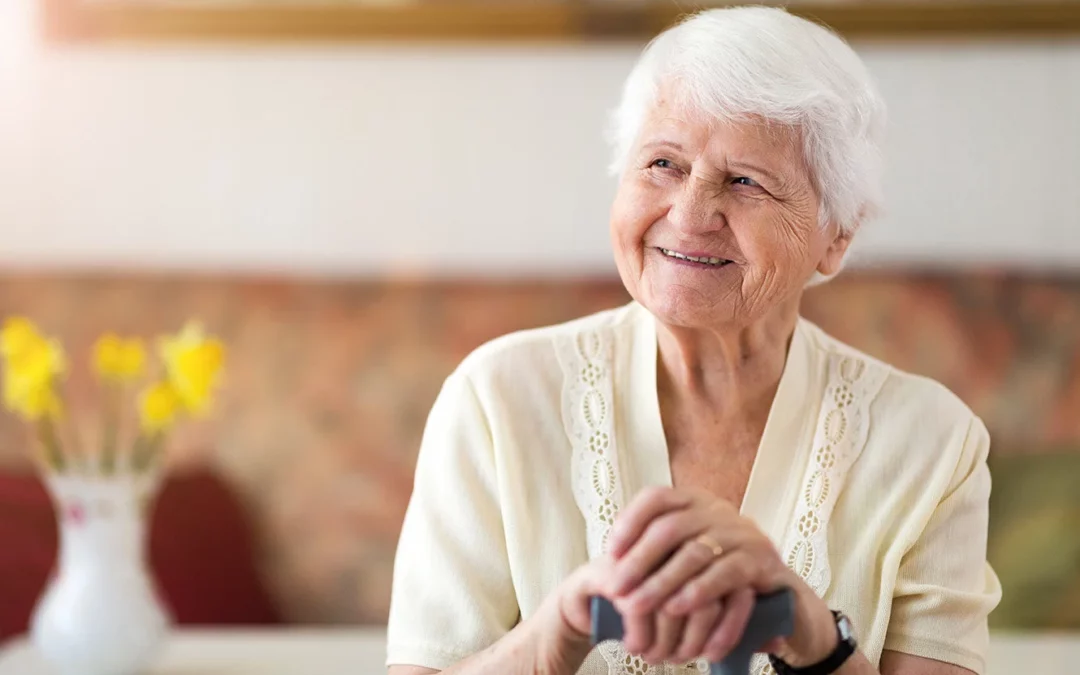 Femme âgée souriante qui dépend d'un GIR (Groupe Iso-ressources)