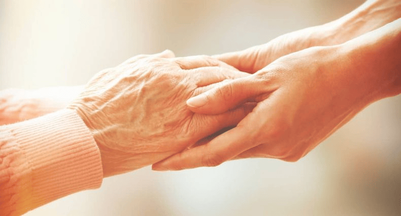 Les mains d'une personne âgée atteinte de la maladie d'Alzheimer et d(une auxiliaire de vie.