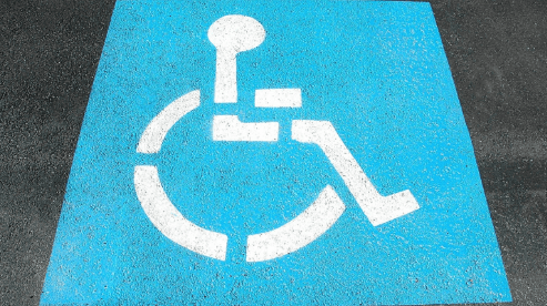 Place pour handicapés avec le symbole de l’handicap. Il permet aux personnes bénéficiant de la PCH de pouvoir se garer.