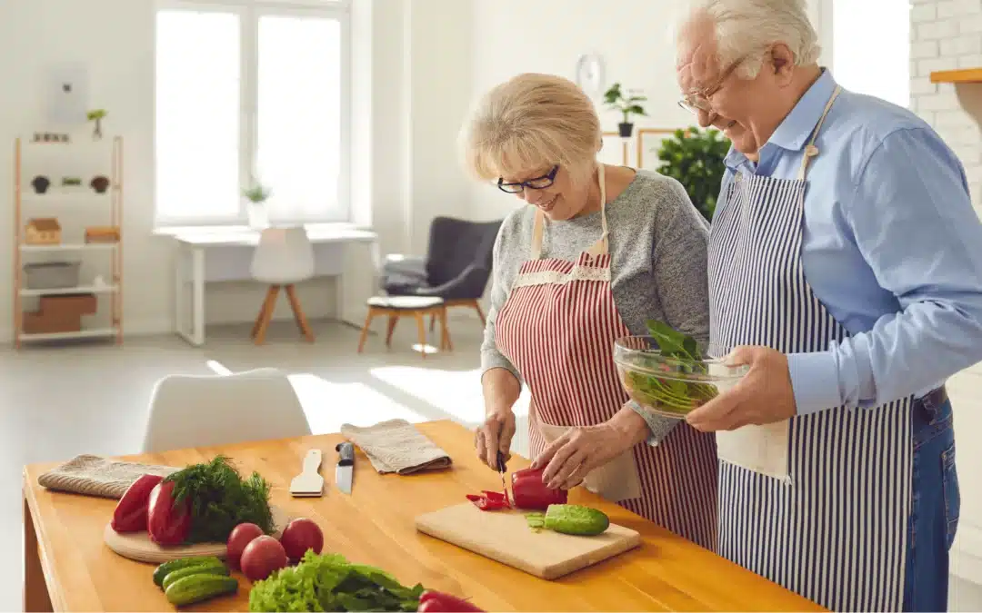 Un couple de personnes âgées cuisinant dans leur cuisine